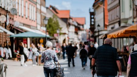 Personen gehen durch die Breite Straße, der Einkaufsmeile in Wernigerode.