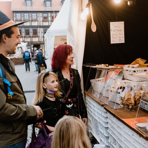 Eine Familie steht zum Schokoladenfestival chocolART an einem Verkaufsstand auf dem Marktplatz in Wernigerode.