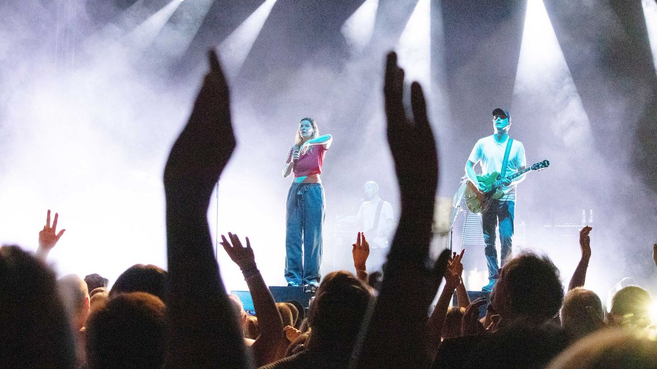 Die Band "Juli" steht auf der Bühne im Scheinwerferlicht zum MDR harz Open Air. Aus dem Publikum werden zwei Arme in die Höhe gehalten.