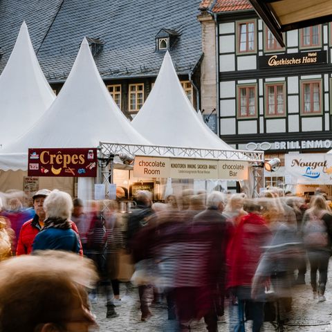 Auf dem Marktplatz von Wernigerode stehen Stände zum Schokoladenfestival chocolART. Menschen laufen entlang der Verkausstände.