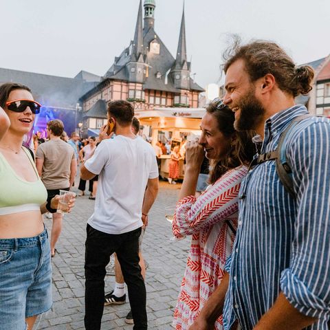 Besucher des Rathausfest in Wernigerode stehen auf dem Marktplatz und unterhalten sich.