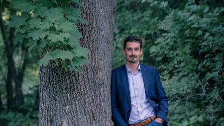 Andreas Meling, Geschäftsführer der Wernigerode Tourismus GmbH steht an einen Baum gelehnt.