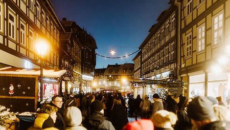 Viele Menschen gehen durch die mit Weihnachtsständen flankierte Breite Straße in Wernigerode