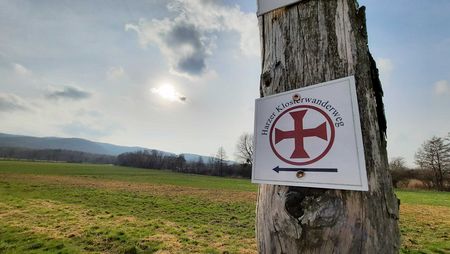 Eine Wegemarkierung des Harzer Klosterwanderweges hängt an einem Baum